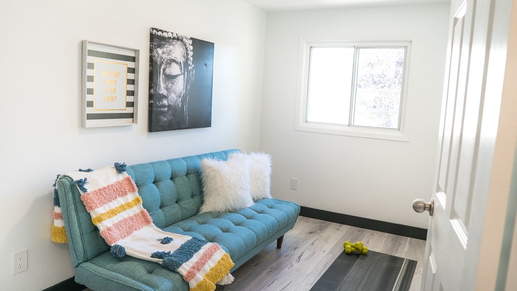 A blue couch with a striped blanket on it.