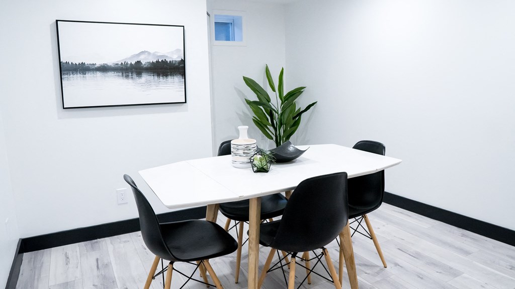 A dining table with four chairs and a potted plant on it.