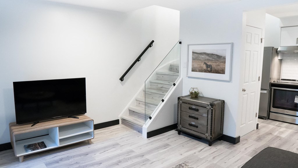 A modern living room with a staircase leading to the upper floor.