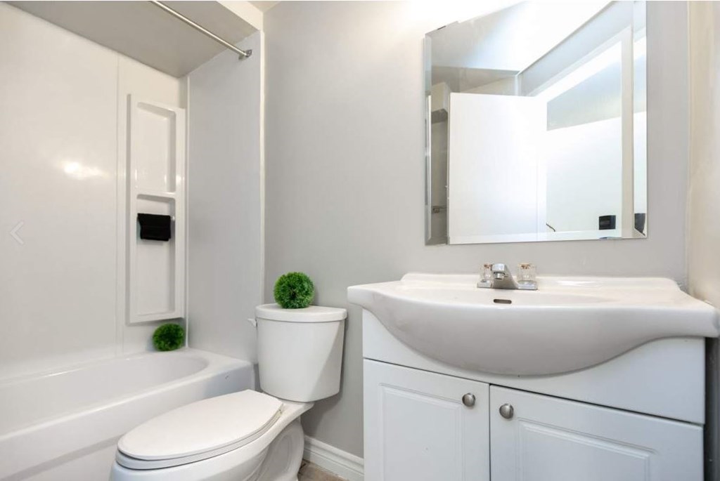 A white bathroom with a toilet, sink, and bathtub.