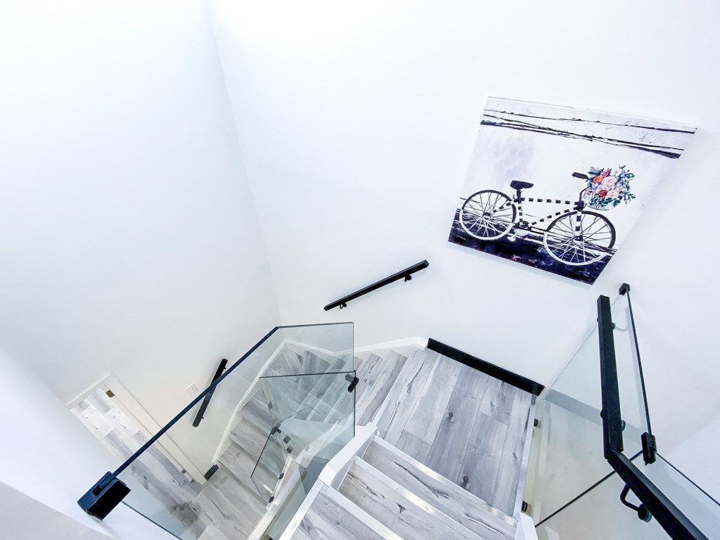 A glass staircase with a picture of a bicycle on the wall.