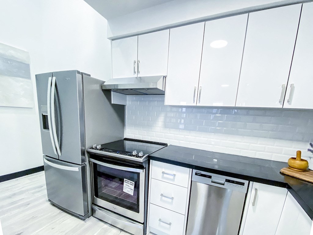 A modern kitchen with a stainless steel refrigerator and oven.