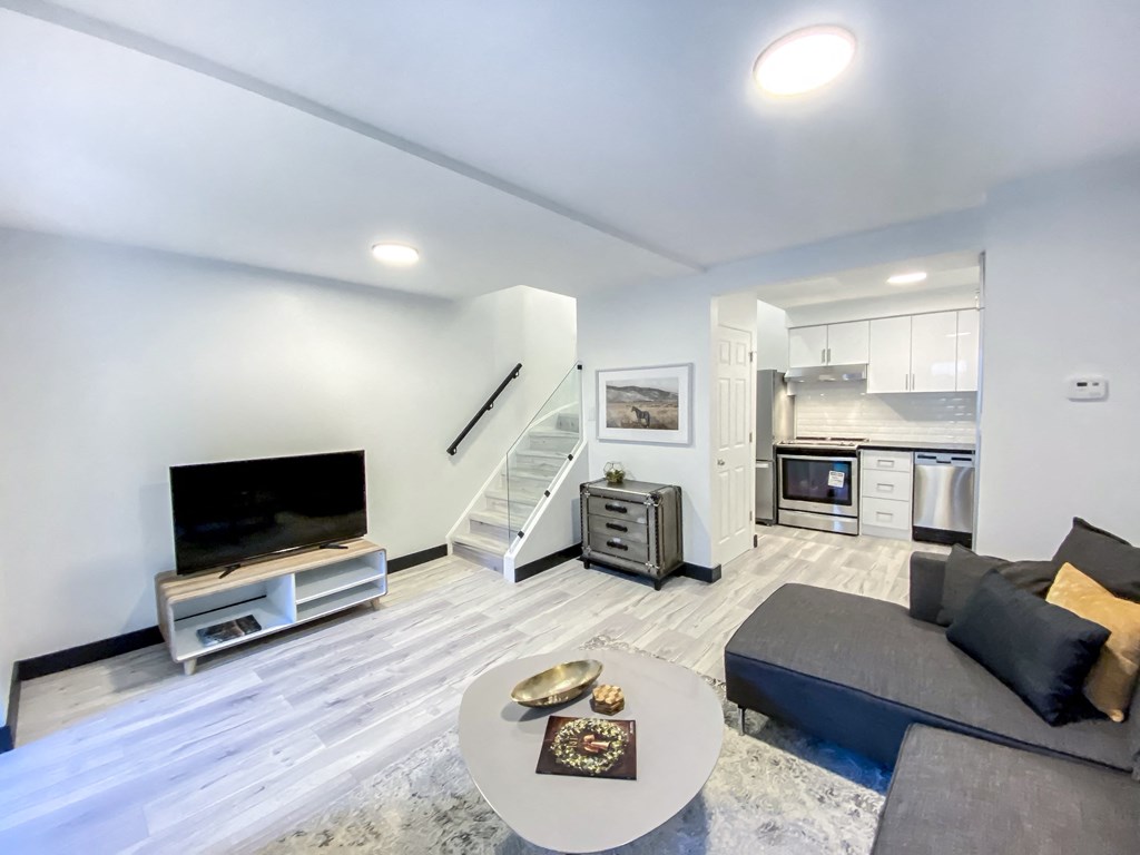 A modern living room with a grey couch and a white coffee table.
