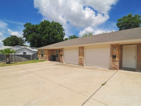 a brick house with a driveway and a garage door