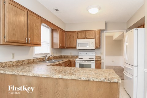 A kitchen with wooden cabinets and a granite countertop.