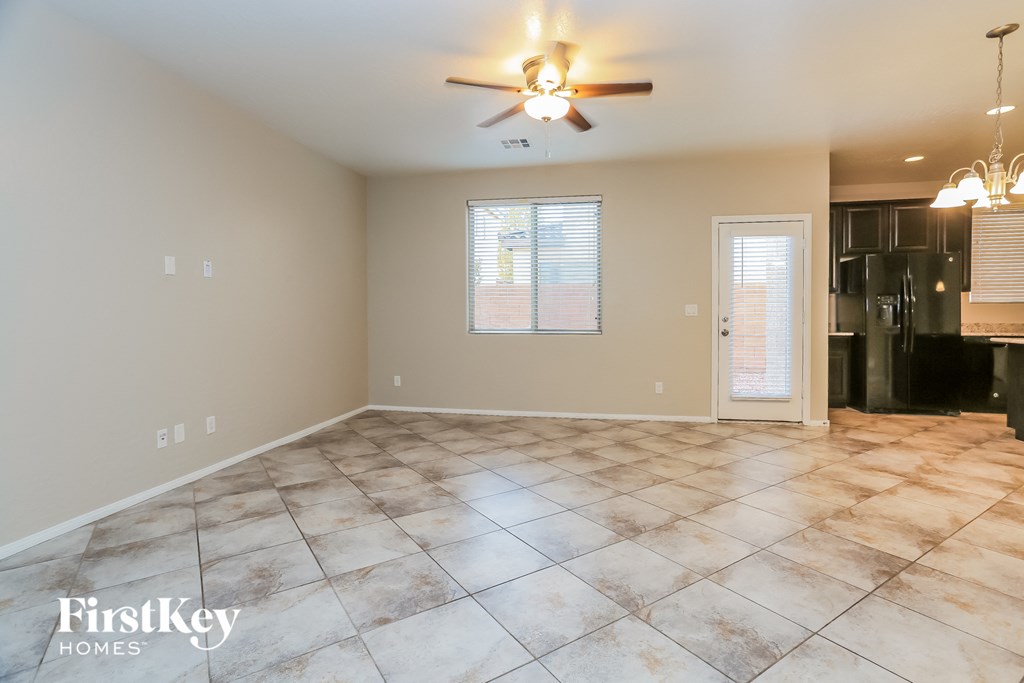 A spacious room with a ceiling fan and tiled floor.