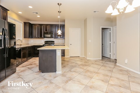 A kitchen with a black refrigerator and a black and white island.