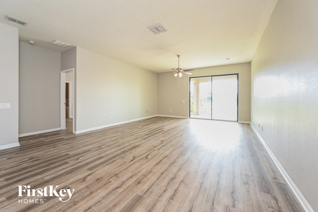 the living room and dining room of an empty house with wood flooring