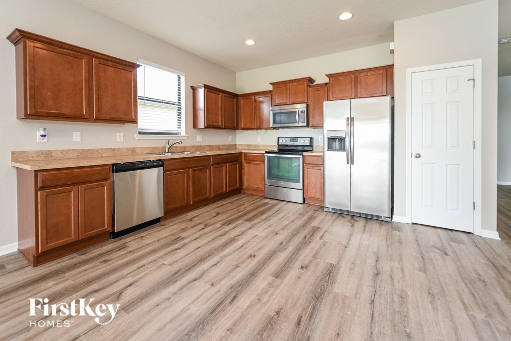 a kitchen with wooden cabinets and stainless steel appliances