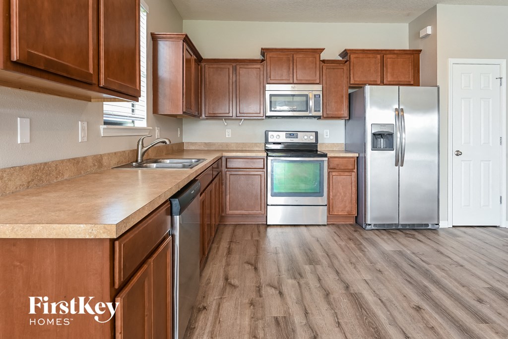 a kitchen with wooden cabinets and stainless steel appliances