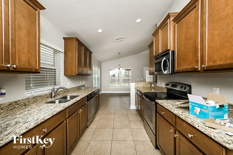 A kitchen with brown cabinets and granite countertops.