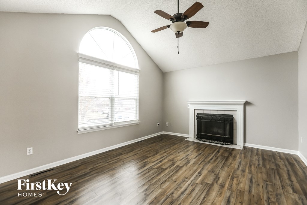 A room with a fireplace and a ceiling fan.