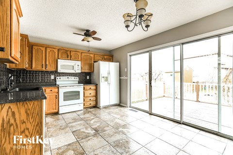 A kitchen with wooden cabinets and a black counter top.