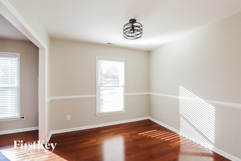 a living room with wood floors and a light fixture on the ceiling