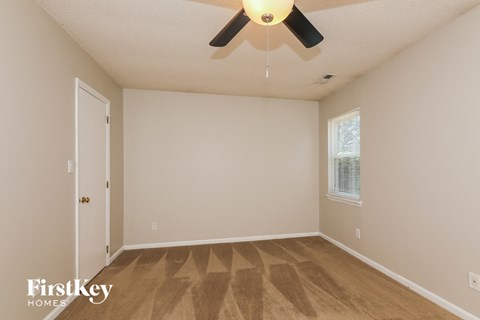 an empty room with a ceiling fan and a door