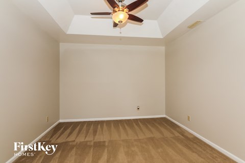 a empty room with wooden floors and a ceiling fan