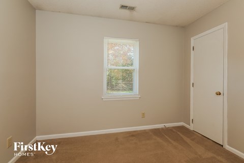 a bedroom with a carpeted floor and a window