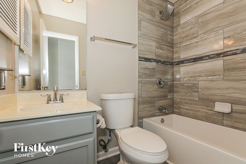 a bathroom with a toilet and a tub and a sink