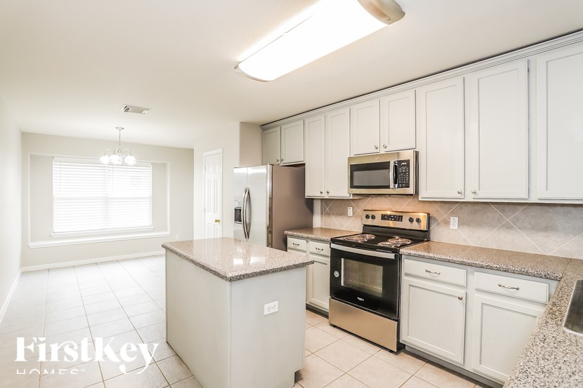 A kitchen with white cabinets and appliances.