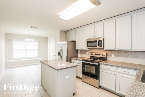 A kitchen with white cabinets and appliances.