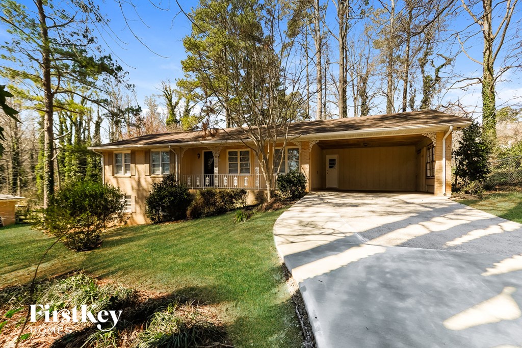 A house with a brown roof and a garage door is surrounded by trees.