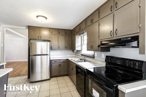 A kitchen with a stove top oven and a refrigerator.