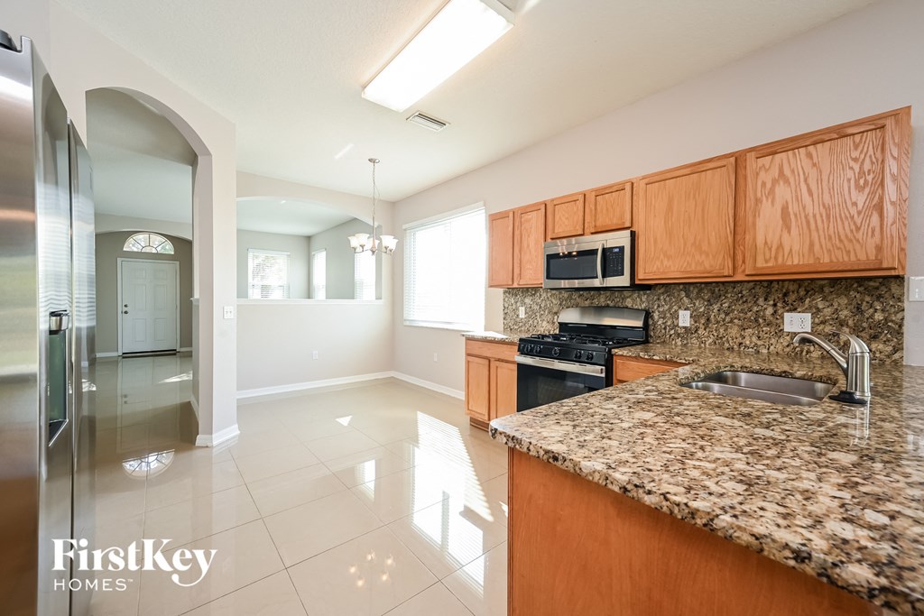 A kitchen with granite countertops and wooden cabinets.