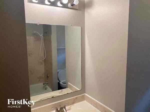 A bathroom with a mirror and lights above it.