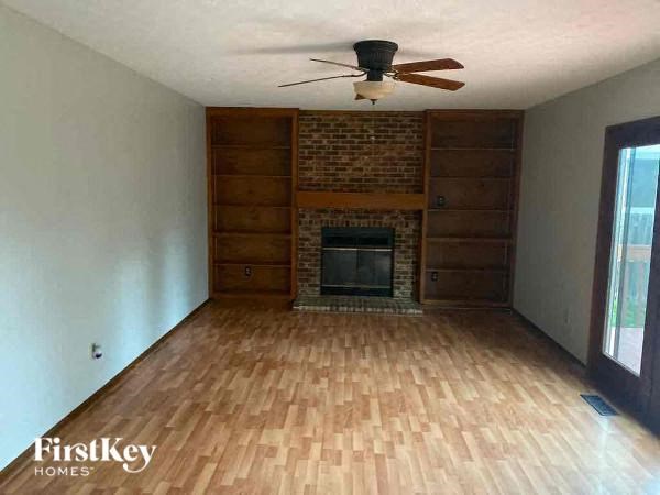 A room with a fireplace and wooden floors.