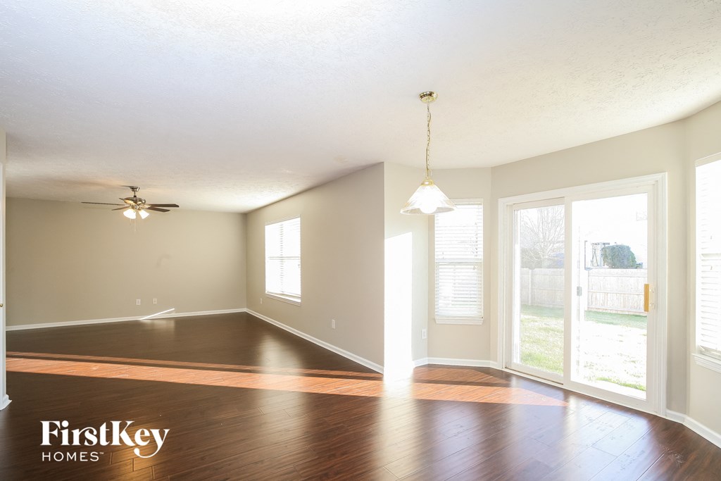 an empty living room with hard wood floors and a window