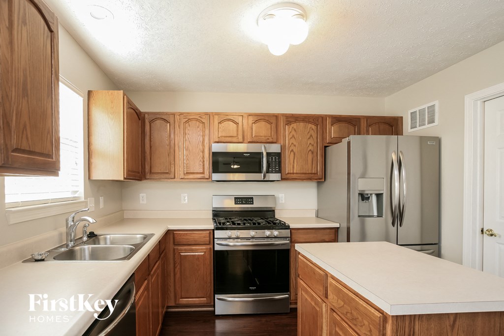 a kitchen with wooden cabinets and stainless steel appliances