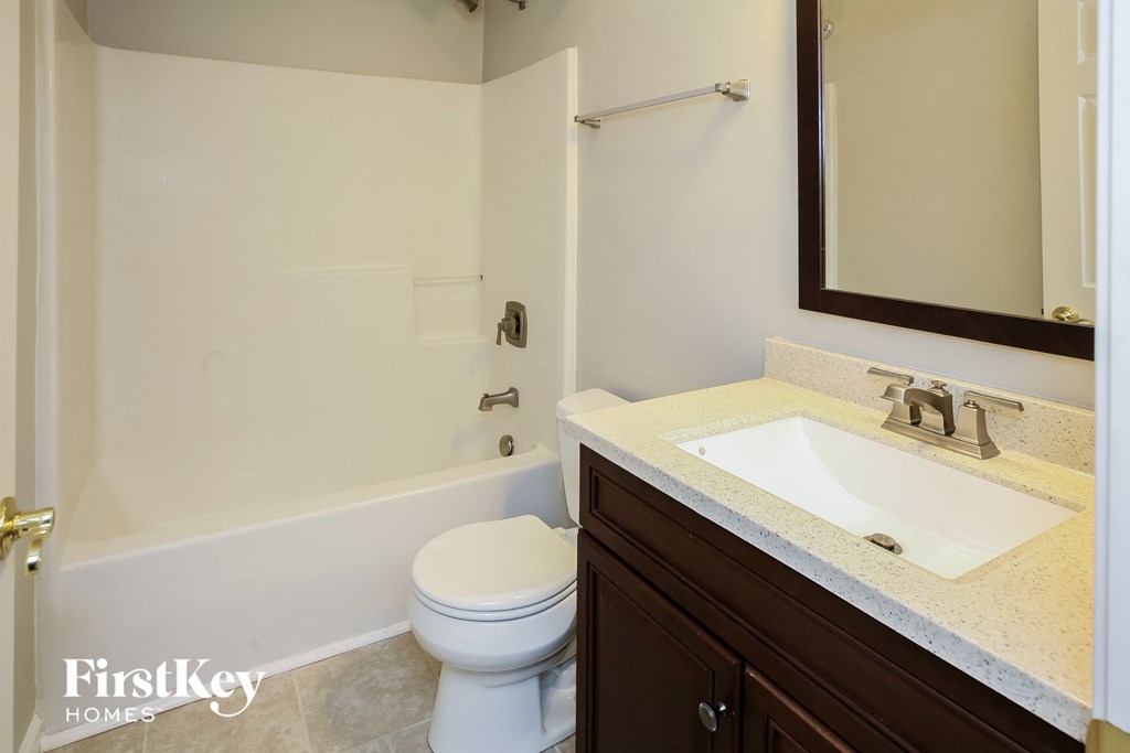 a bathroom with a toilet and a sink and a mirror