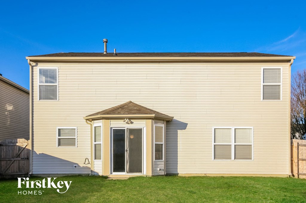 the front of a yellow house with a door and grass