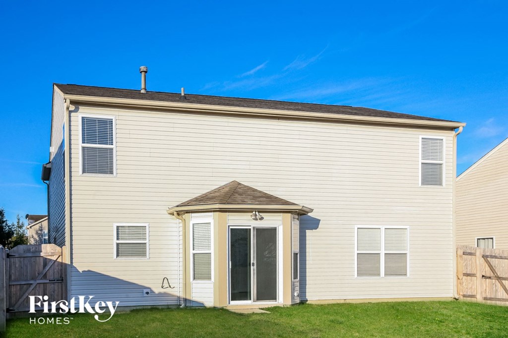 a small white house with a door and a grassy yard