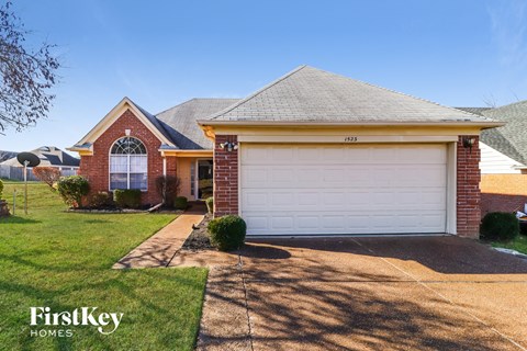 a home with a white garage door and a lawn