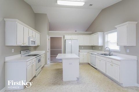 A kitchen with white cabinets and appliances is shown.
