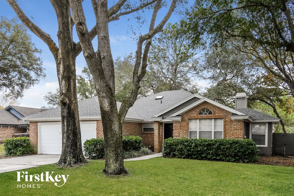 a small brick house with two trees in front of it