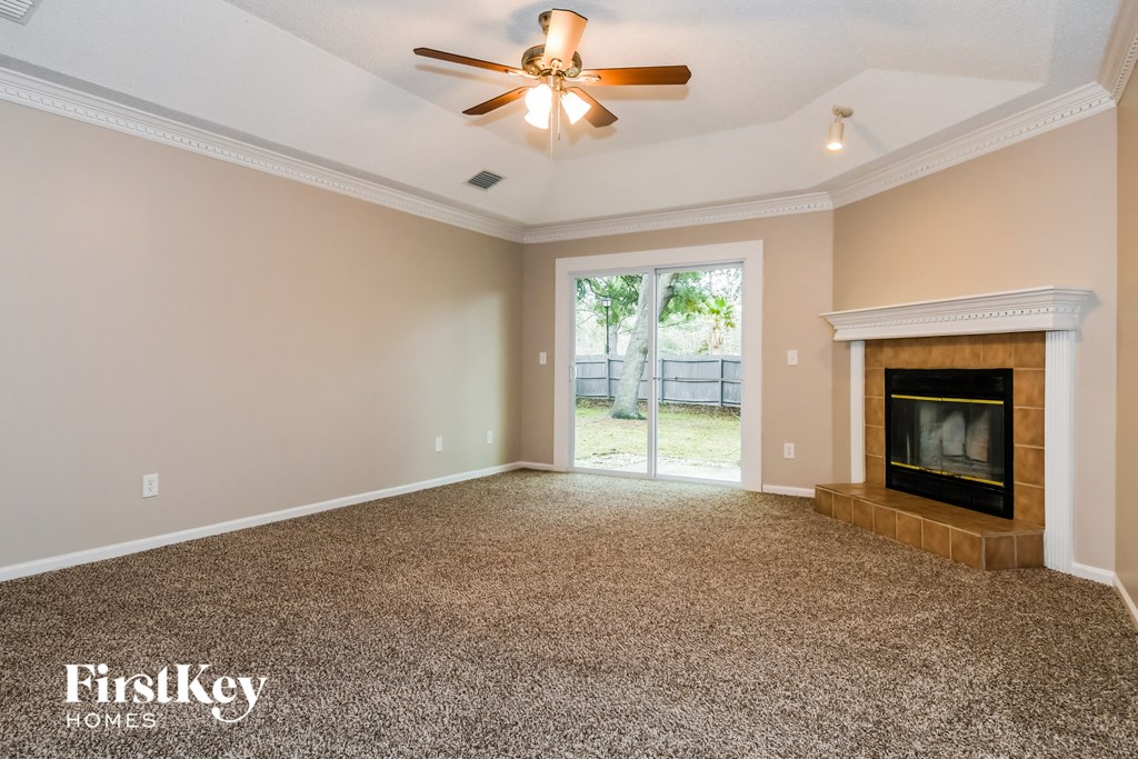 a living room with a fireplace and a ceiling fan