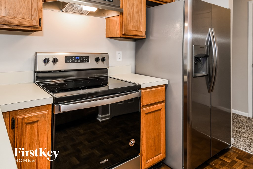 an updated kitchen with stainless steel appliances and wood cabinets