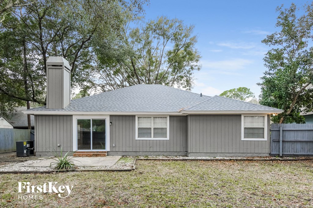front view of a gray house with trees in the background