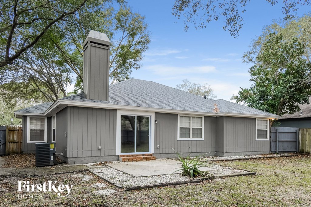 front view of a gray house with a yard and trees