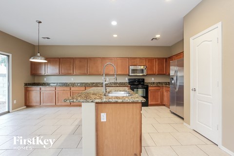 a large kitchen with granite counter tops and wooden cabinets
