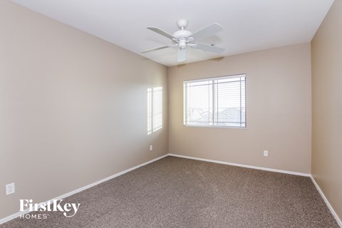 a bedroom with a ceiling fan and a window