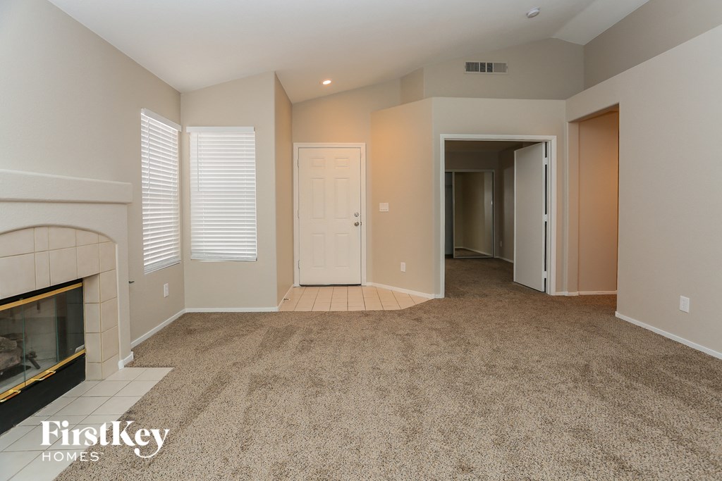 a living room with a fireplace and a carpeted floor