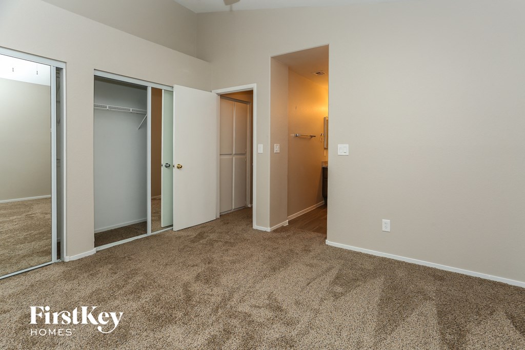 a bedroom with three closets and a carpeted floor