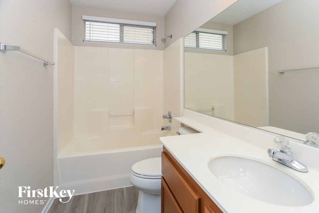 a bathroom with a sink toilet and tub and a mirror