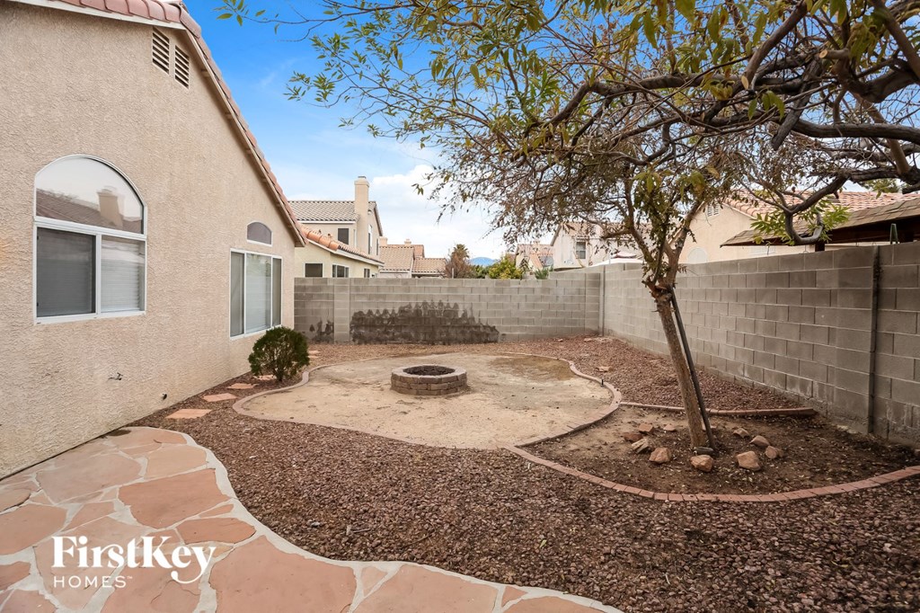 a backyard with a tree and a fire pit