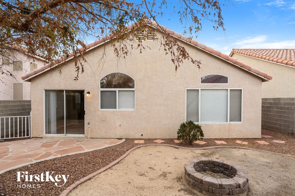 the front of a house with a patio and a fire pit