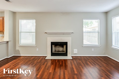 a living room with a fireplace and wooden floors