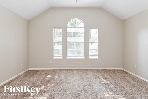 the second bedroom with carpet and three windows